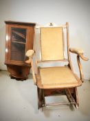 A mahogany rocking chair in studded dralon fabric, together with a hanging corner wall cabinet.