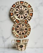 A Royal Crown Derby Imari porcelain teacup, saucer, and plate trio, unfilled gold band border,