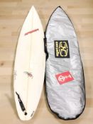 A surfboard, together with two wetsuits.