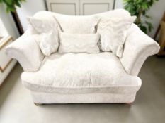 A contemporary two seater settee, with scatter cushions, in cream upholstery,