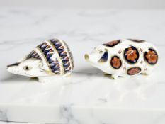 A Royal Crown Derby Hedgehog paperweight, gold stopper, and a further pig, length 12.