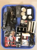 A group of cuff links, collectors coins, harmonica, a miniature folding axe, holster, sunglasses,