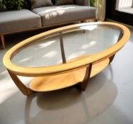 A teak oval glass inset coffee table, length 120 cm.