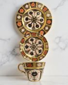A Royal Crown Derby Imari porcelain teacup, saucer, and plate trio, filled gold band border,