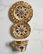 A Royal Crown Derby Imari porcelain teacup, saucer, and plate trio, filled gold band border,