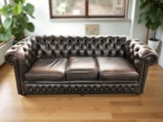 A Chesterfield style buttoned brown leather three seater settee,