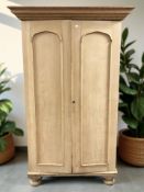 A late Victorian pine double door wardrobe on bun feet, 111 cm x 77 cm x 181 cm.