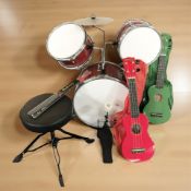 A child's drum set and two ukuleles.