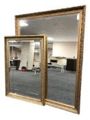 Three contemporary gilt and bevelled mirrors, the larger 112 cm x 86 cm.