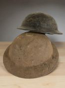 Two tin brodie helmets.