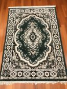 A machine made rug of Iranian design, on green ground, 205 cm x 136 cm.