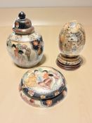 A group of three Japanese ceramic decorative items including a lidded urn on stand,