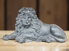 An early 20th century cast iron boot scraper in the form of a recumbent lion, width 69 cm.