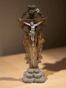 A carved beech and silvered metal crucifix,