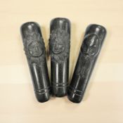 Three small carved eastern chillum pipes with carved Chinese man and sun faces.