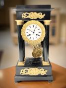 A French ebonised and gilt metal portico mantel clock, signed Revillon A Macon,