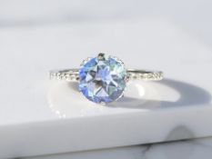 A 9ct white gold ring with faceted central blue stone and white stones set to shoulders,