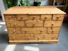 A contemporary pine thirteen drawer chest, 126 cm x 47 cm x 87 cm.