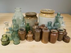 A group of antique glass and stoneware bottles and jars.