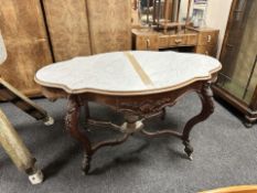 A Victorian carved mahogany and white marble-inset occasional table, width 129 cm.