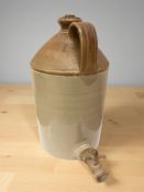 A stoneware bottle with tap, height 40 cm.