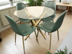 A contemporary glass topped circular dining table on metal supports,