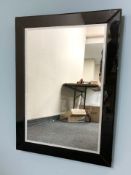 A contemporary black glass framed mirror, 90 cm x 65 cm.