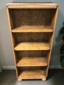 An Edwardian oak open bookcase on bun feet,