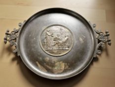 A bronze twin handled pedestal dish, with inset plaque, width 34 cm.