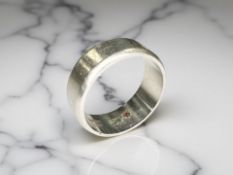 A platinum band ring, the interior inset with an emerald and ruby, size U.