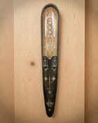 An African carved hardwood and mother of pearl inlaid wall mask, height 150 cm.
