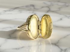 A nineteenth century yellow metal mourning ring with hinged compartmental cover, size K.