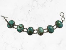 A Continental white metal bracelet set with panels of turquoise, backed in Sterling silver,