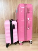 An IT pink luggage case, height 81 cm, and a further smaller luggage case.