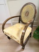 An Art Deco walnut low armchair with caned back, width 53 cm.