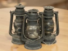 Three antique oil lamps.