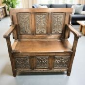 A 20th century carved oak storage monk's bench, length 100 cm.