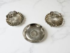 A pair of silver shell-form dishes and a further coin-inset dish, diameter 6.5cm.