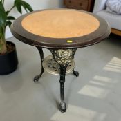 A pub table on cast metal support, diameter 69 cm.