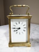 A brass-cased carriage timepiece, with lever platform escapement, height 14cm including handle.