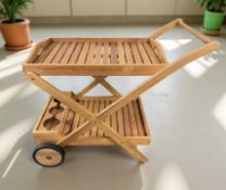 A modern teak two-tier drinks trolley, length 100 cm.