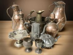 A collection of antique brass, copper and pewter wares, swing handled cooking pots, large tea pots,