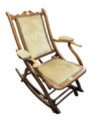 A 19th century walnut and studded dralon rocking chair, length 80 cm.