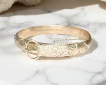 An antique 9ct yellow gold bangle with engraved belt clasp decoration, diameter 60 mm x 55 mm.