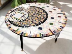 A mosaic circular coffee table on splayed ebonised legs, diameter 83 cm.