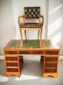 A reproduction yew wood twin pedestal writing desk with tooled green leather inset panelled top,