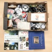 A collection of fishing equipment including various spools of line, fishing flies, books,