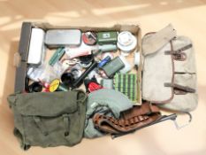 A collection of fishing equipment including various spools of line, canvas bags, foldign multi tool,