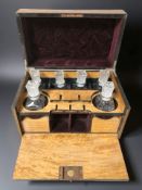 A burr walnut drinks box containing six pressed glass decanters, width 40 cm.