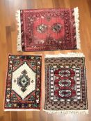 A Turkoman rug, Afghanistan, 72 cm x 55 cm, together with two further small rugs.